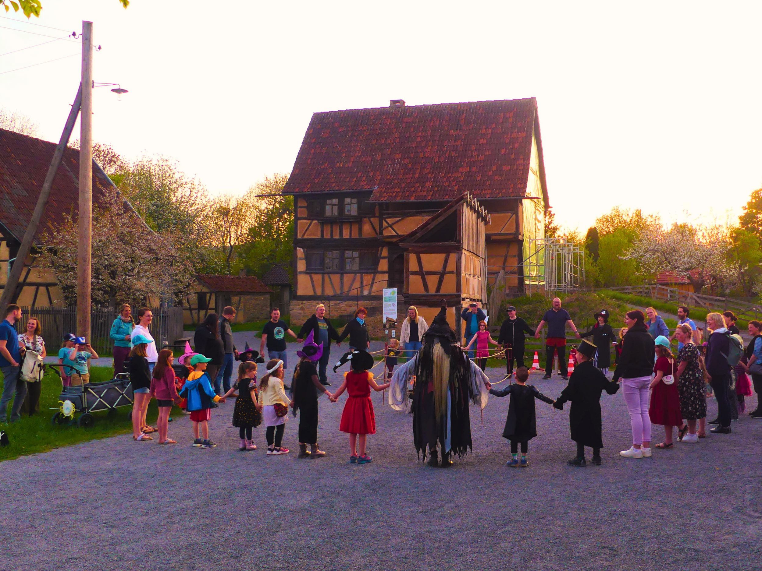 Gleich wird das Feuer entfacht: Beim gemeinsamen Tanz mit Hexe Walpurga klingt die Walpurgisnacht am 30. April im Fränkischen Freilandmuseum Fladungen stimmungsvoll aus. Foto: Monika Trost.